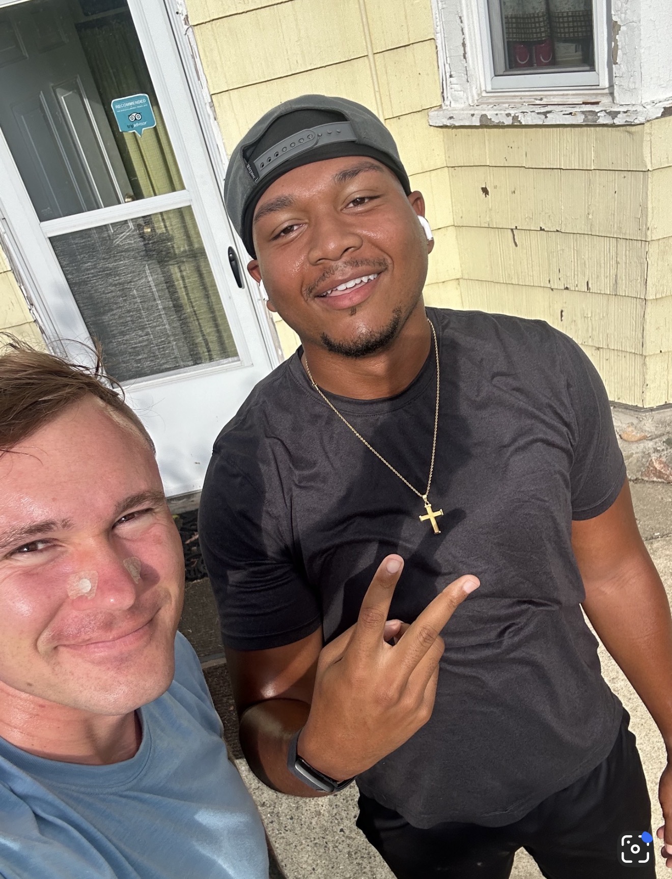 Two teammates smiling together outside a house