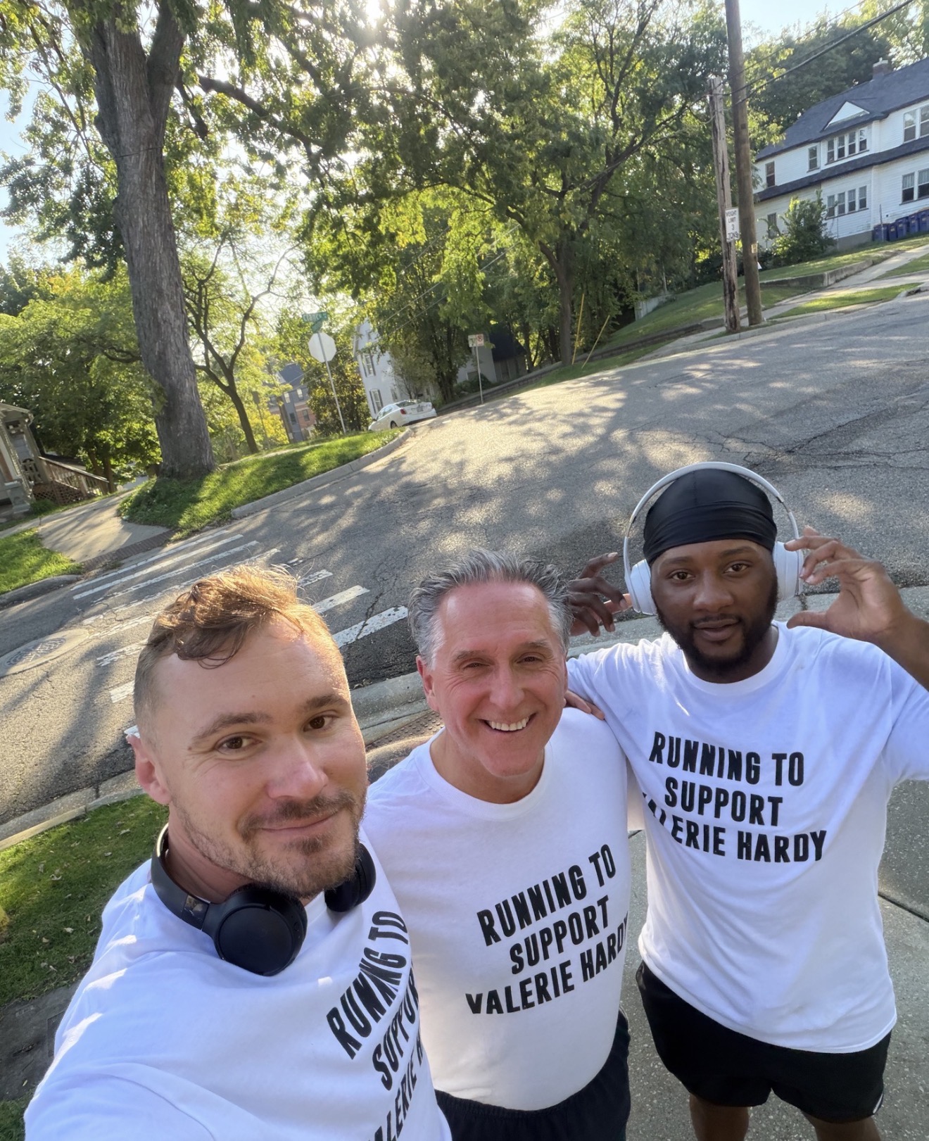 Three teammates taking a selfie outdoors in support shirts