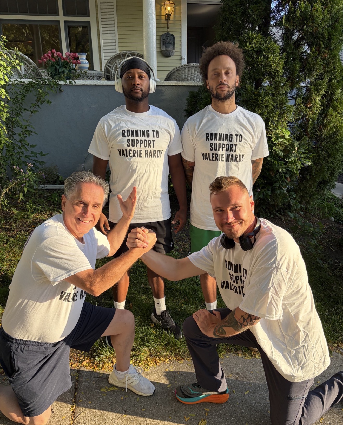 Four teammates posing together outdoors in support shirts