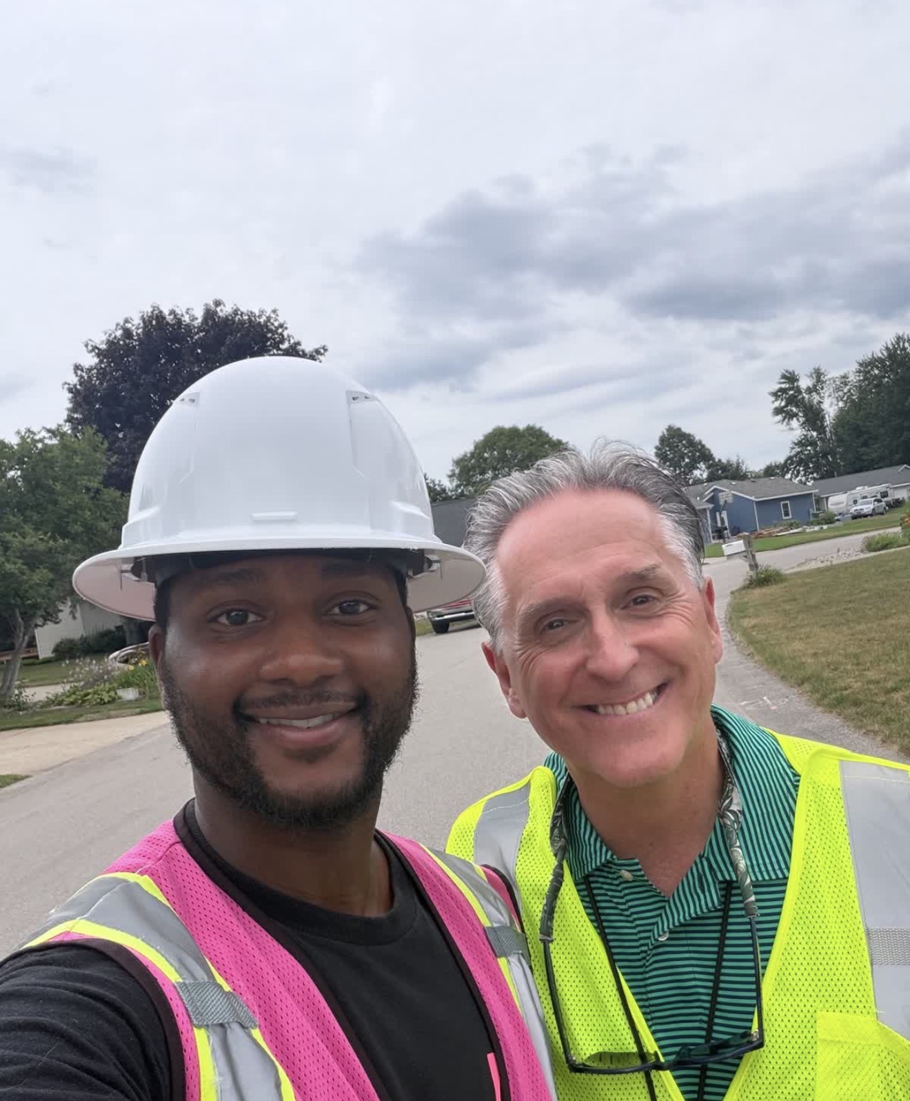Two Marathon team members wearing safety vests in a neighborhood